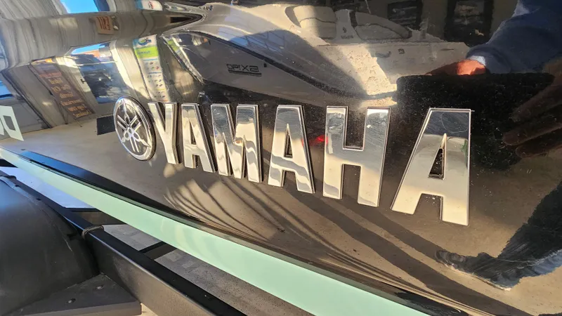 Slide: The Image of 2023 Yamaha Boats AR250 logo on sleek black surface, reflecting surroundings. - 29