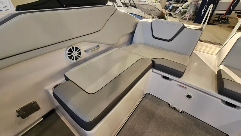 Slide: The Image of 2023 Yamaha Boats AR250 interior seating with gray upholstery and speaker. - 7