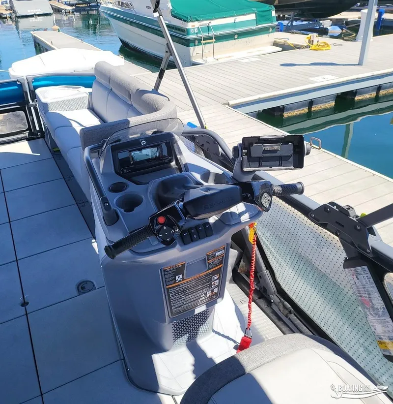 Slide: The Image of 2023 Sea-Doo Switch Cruise 21 dashboard with controls and seating at a marina. - 17