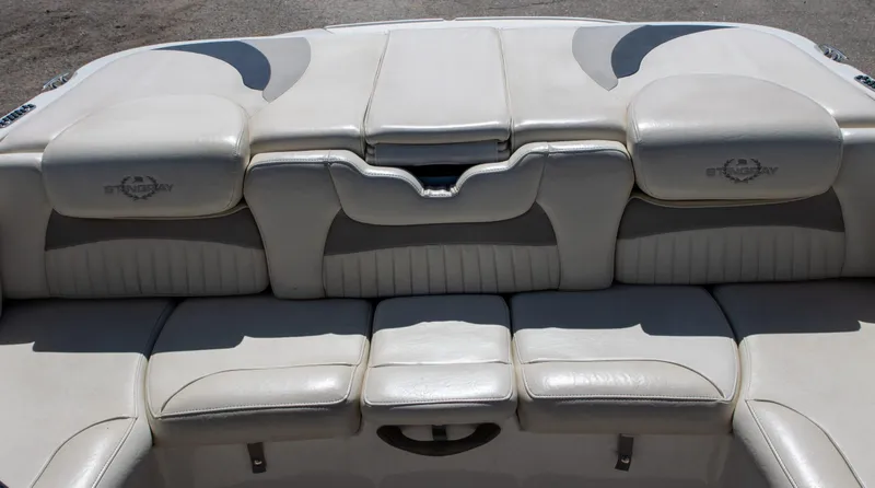 Slide: The Image of 2013 Stingray 225 LR boat interior with white leather seating and logo. - 10