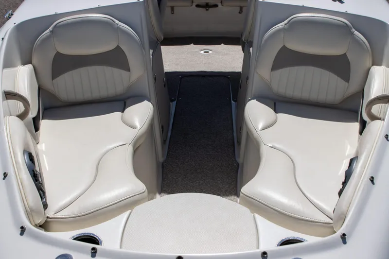 Slide: The Image of 2013 Stingray 225 LR boat interior with white leather seating and carpeted floor. - 7