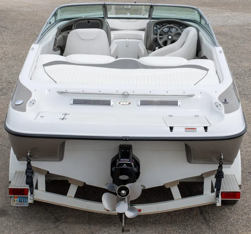 Slide: The Image of 2003 Crownline 225 BR boat, rear view, on trailer, showcasing interior and propeller. - 10