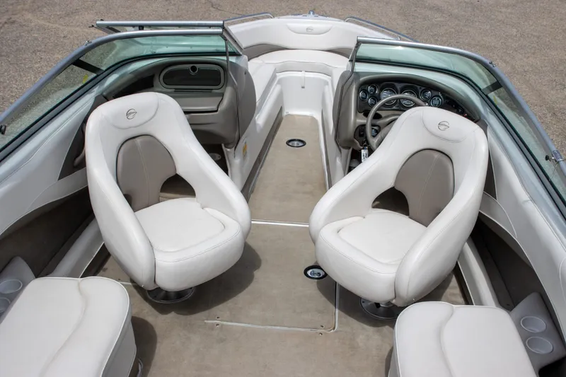 Slide: The Image of 2003 Crownline 225 BR boat interior with white seating and dashboard view. - 3