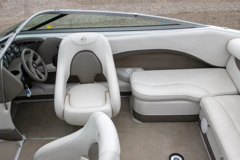 Slide: The Image of 2003 Crownline 225 BR boat interior with beige seating and steering wheel. - 4