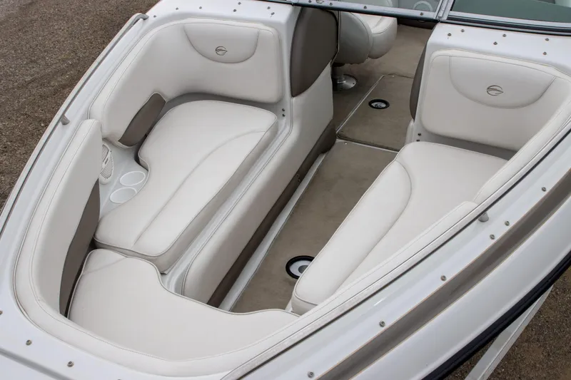 Slide: The Image of 2003 Crownline 225 BR boat interior with white cushioned seating and cup holders. - 6