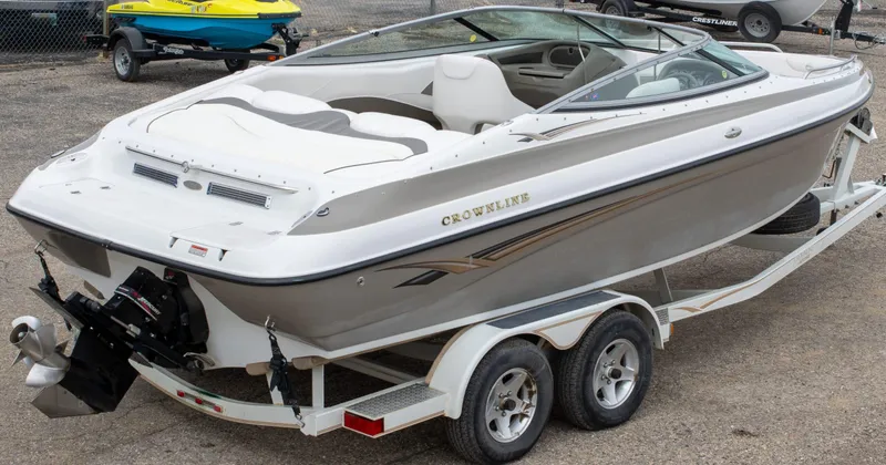 Slide: The Image of 2003 Crownline 225 BR boat on trailer, white and gray exterior, parked outdoors. - 8