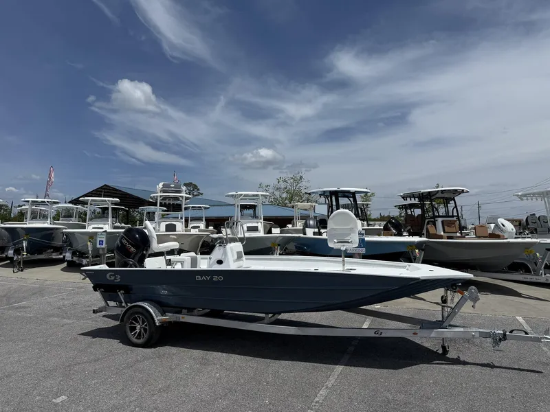Slide: The Image of 2025 G3 Bay 20 boat on trailer in dealership lot under blue sky. - 1