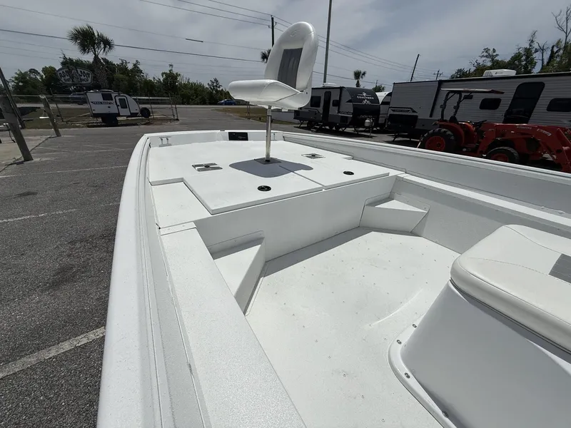 Slide: The Image of 2025 G3 Bay 20 boat interior with elevated seat, parked near trailers and tractor. - 7