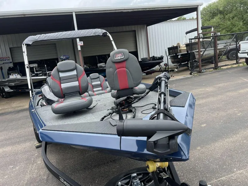 Slide: The Image of 2022 Ranger RT178C fishing boat with dual seats and trolling motor, parked outside a garage. - 16