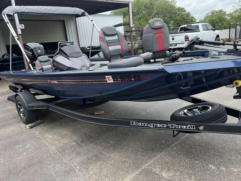 Slide: The Image of 2022 Ranger RT178C boat on trailer, blue with red accents, parked outdoors. - 18