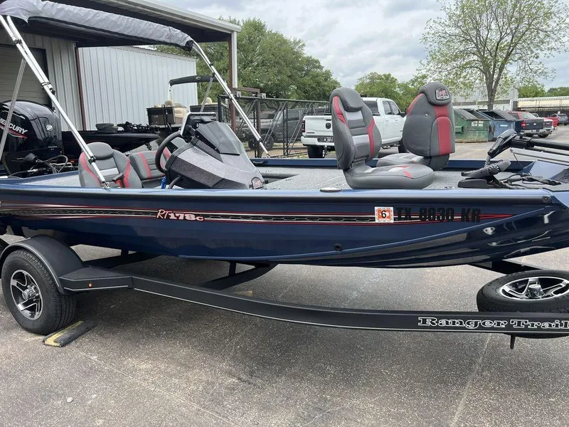 Slide: The Image of 2022 Ranger RT178C fishing boat on trailer, featuring dual seats and a canopy. - 22