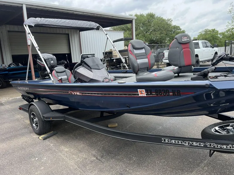 Slide: The Image of 2022 Ranger RT178C boat on trailer, parked outdoors near a garage. - 23