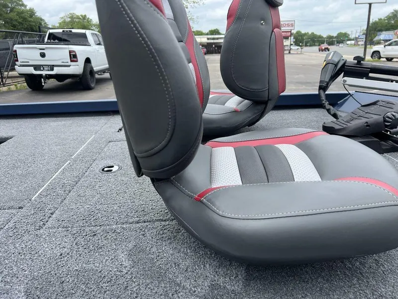 Slide: The Image of 2022 Ranger RT178C boat interior with gray and red seats, parked outdoors. - 27