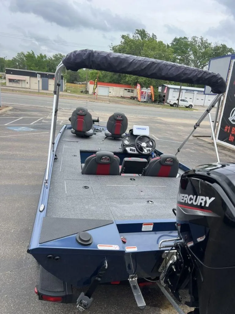Slide: The Image of 2022 Ranger RT178C boat with Mercury engine, parked outdoors, featuring seating and steering console. - 48