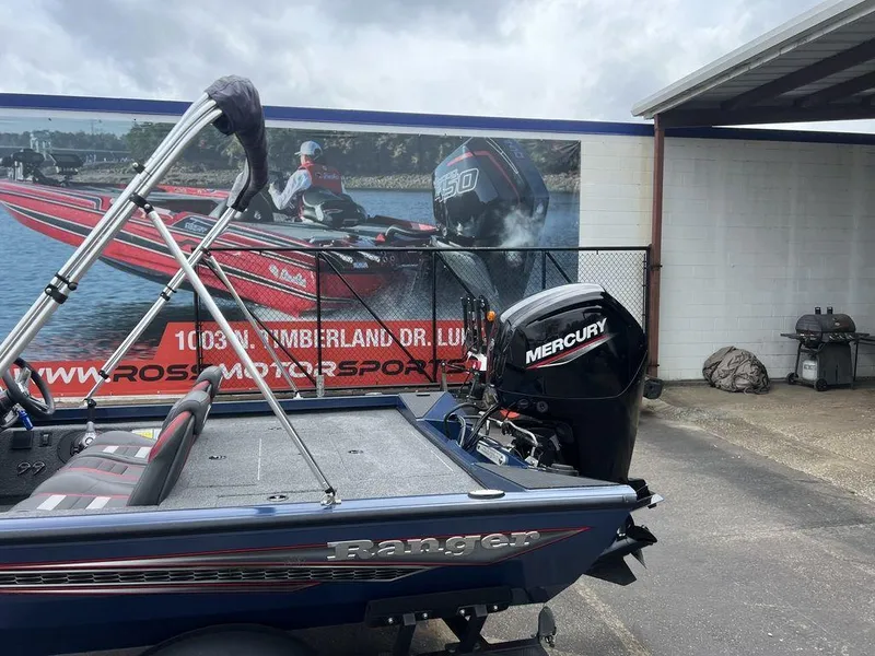 Slide: The Image of 2022 Ranger RT178C boat with Mercury engine parked near a motorsports advertisement. - 7