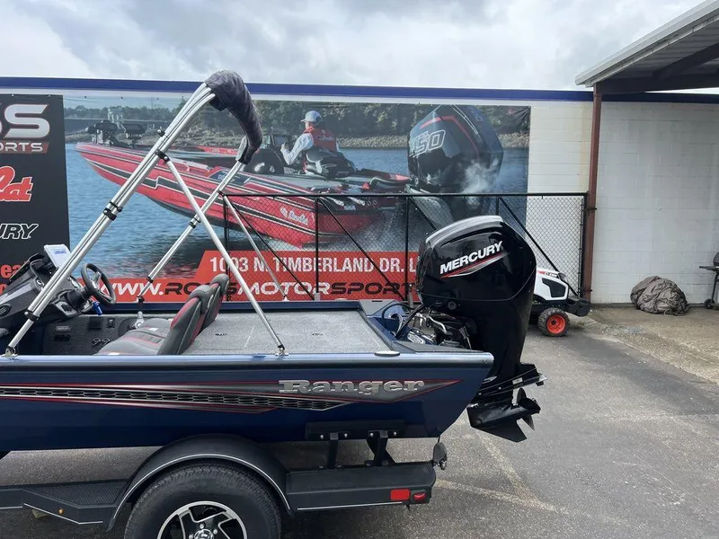 Slide: The Image of 2022 Ranger RT178C boat with Mercury engine, parked near a motorsports advertisement. - 8