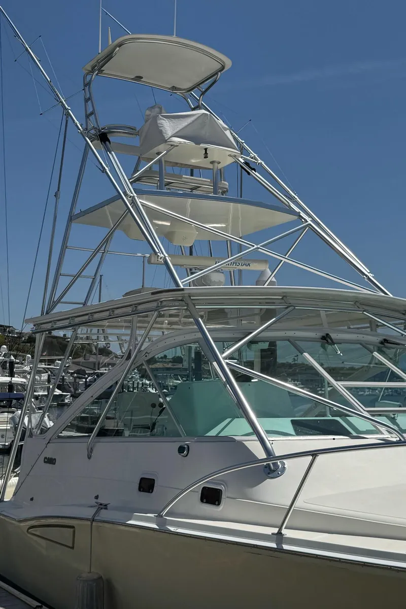 Slide: The Image of 1998 Cabo 35 Express boat with tower, docked under clear blue sky. - 10
