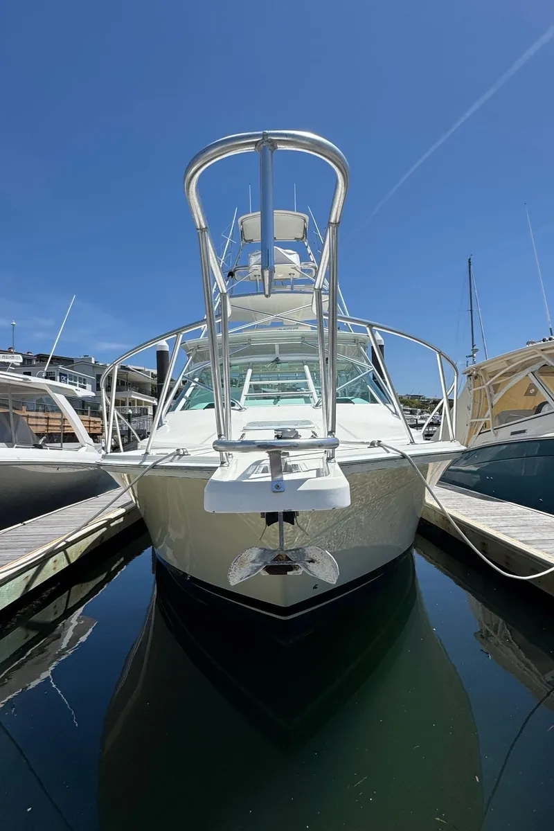 Slide: The Image of 1998 Cabo 35 Express boat docked under clear blue sky. - 12