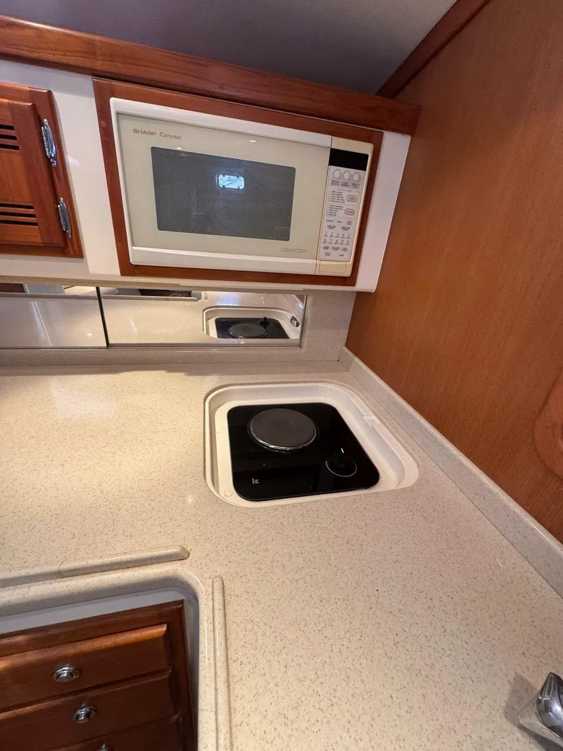 Slide: The Image of 1998 Cabo 35 Express yacht kitchen with microwave and stovetop. - 16