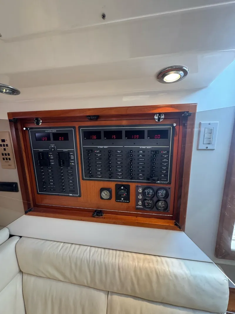 Slide: The Image of 1998 Cabo 35 Express electrical panel with gauges and switches in wooden frame. - 18