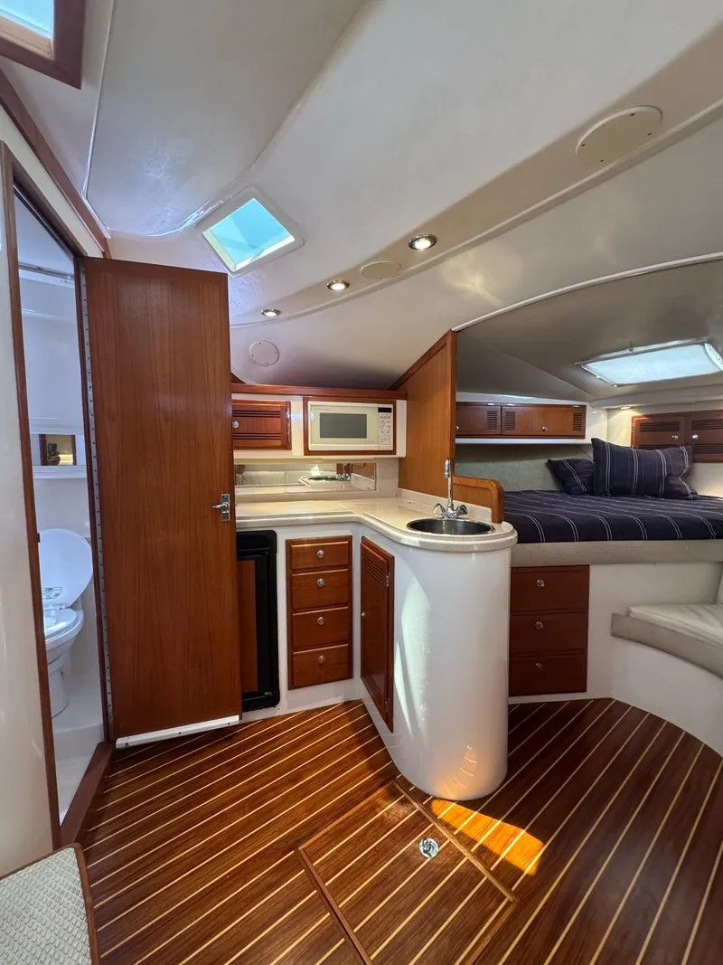 Slide: The Image of 1998 Cabo 35 Express yacht interior with kitchen, seating, and wood flooring. - 20