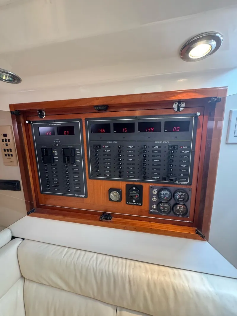 Slide: The Image of Electrical panel of a 1998 Cabo 35 Express boat, featuring switches and gauges. - 23