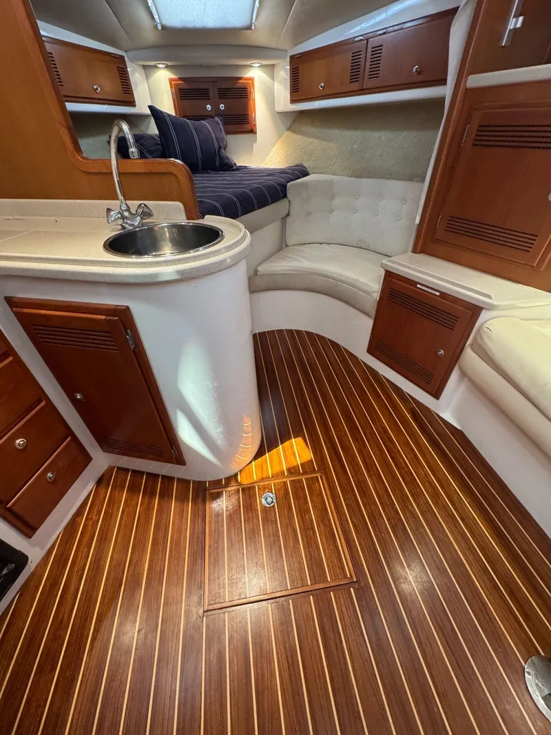 Slide: The Image of 1998 Cabo 35 Express cabin with wood flooring, kitchenette, and cozy seating area. - 24
