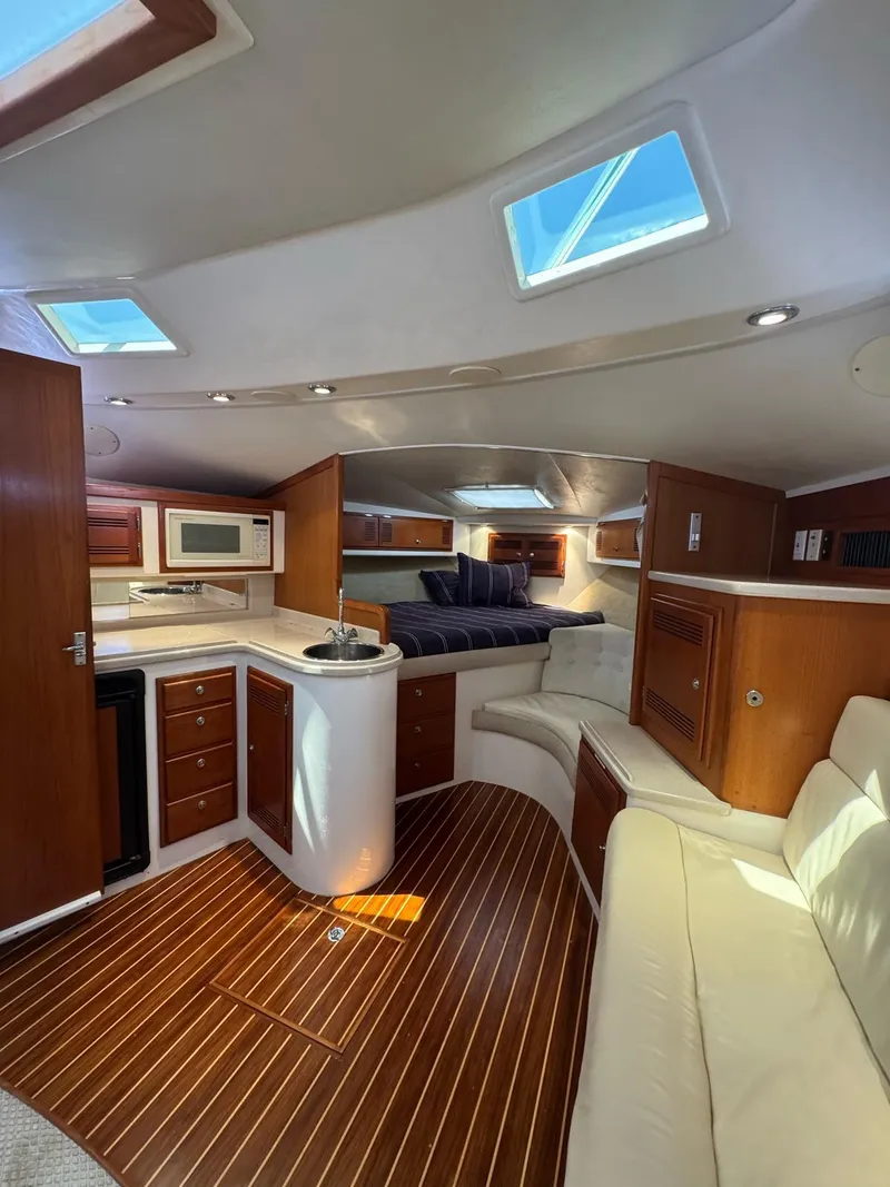 Slide: The Image of 1998 Cabo 35 Express interior with wood flooring, kitchenette, and seating area. - 25