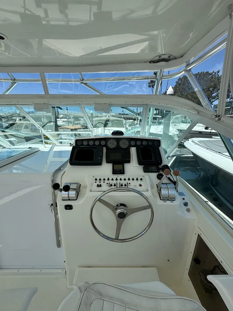 Slide: The Image of 1998 Cabo 35 Express boat helm with steering wheel and control panel. - 27