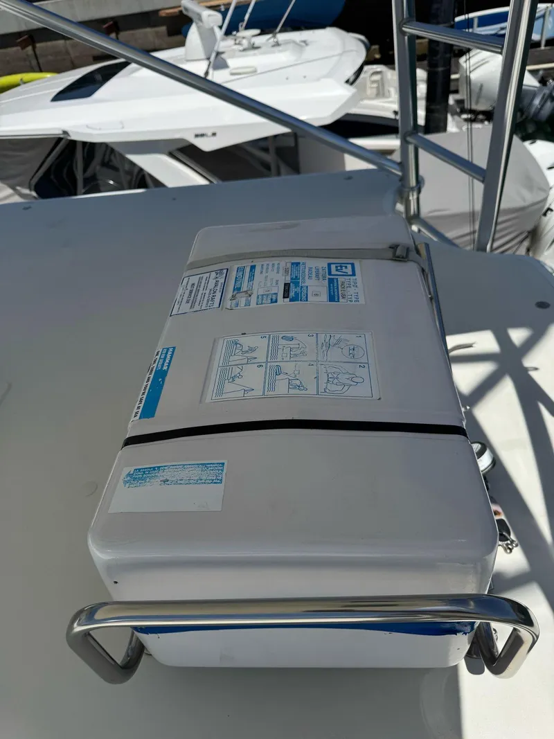 Slide: The Image of Life raft on 1998 Cabo 35 Express boat deck, secured with metal railing. - 28