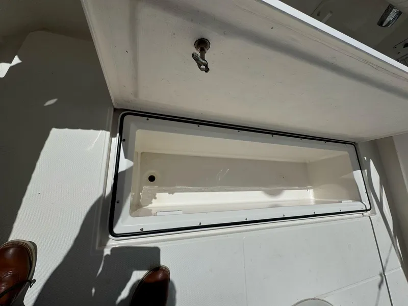 Slide: The Image of 1998 Cabo 35 Express boat storage compartment with open lid, showcasing interior space. - 34
