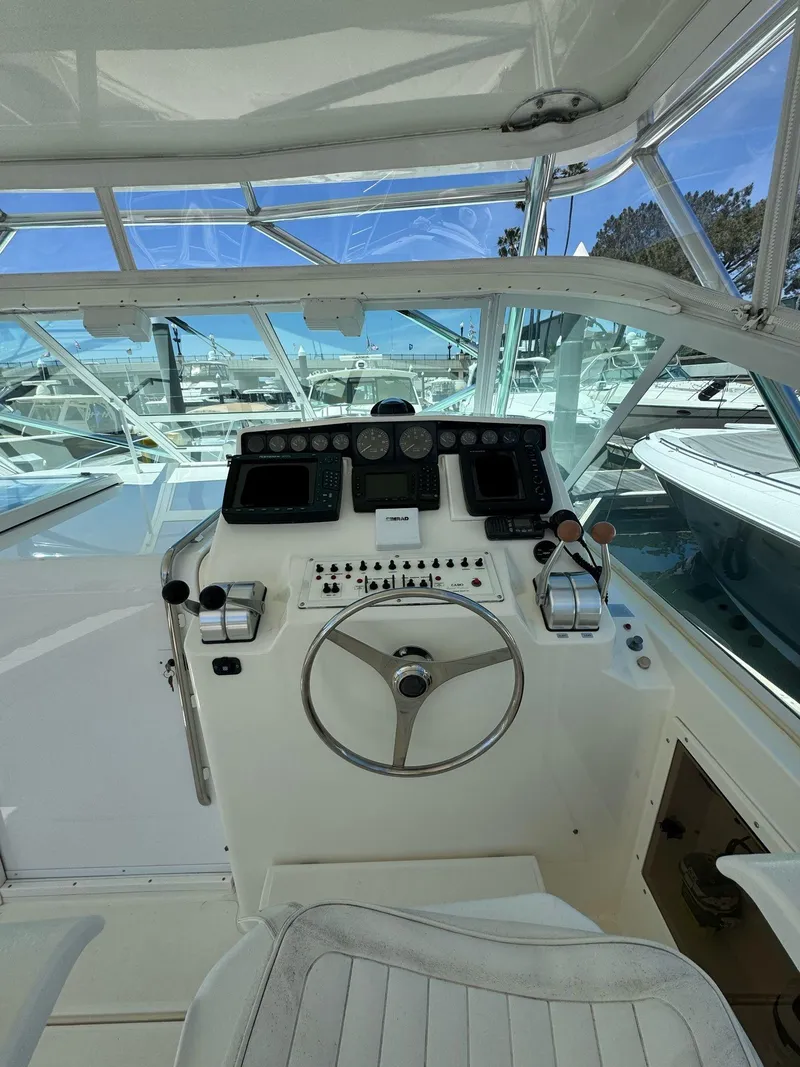 Slide: The Image of 1998 Cabo 35 Express boat cockpit with steering wheel and control panel. - 40