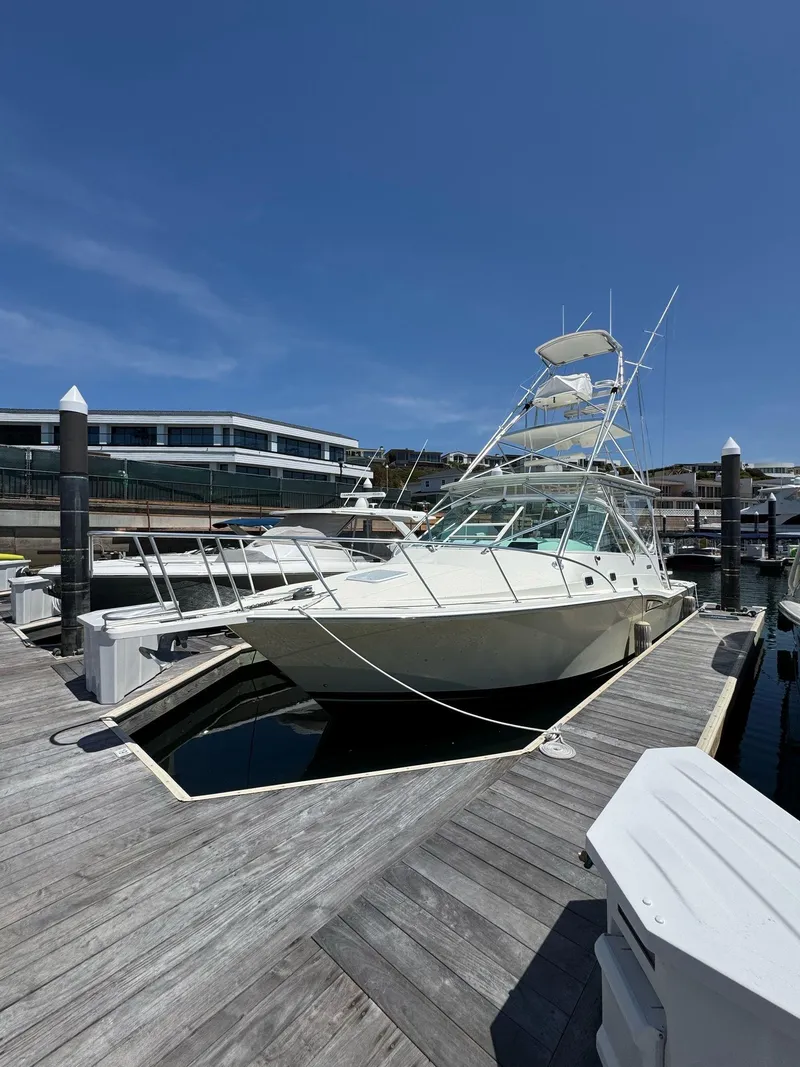 Slide: The Image of 1998 Cabo 35 Express yacht docked at marina under clear blue sky. - 41