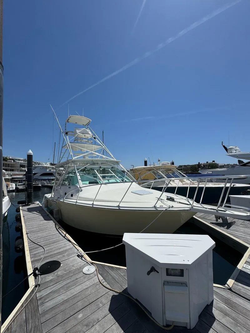 Slide: The Image of 1998 Cabo 35 Express boat docked at marina under clear blue sky. - 43
