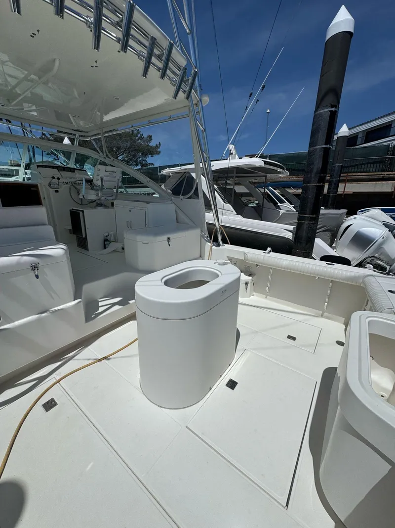 Slide: The Image of 1998 Cabo 35 Express boat deck with seating and storage, docked at marina. - 44