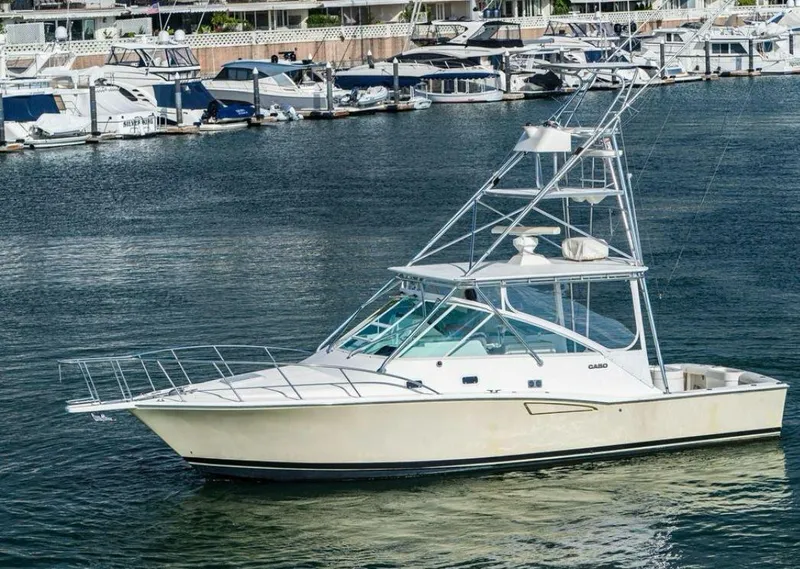 Slide: The Image of 1998 Cabo 35 Express boat docked in marina, surrounded by other vessels. - 46