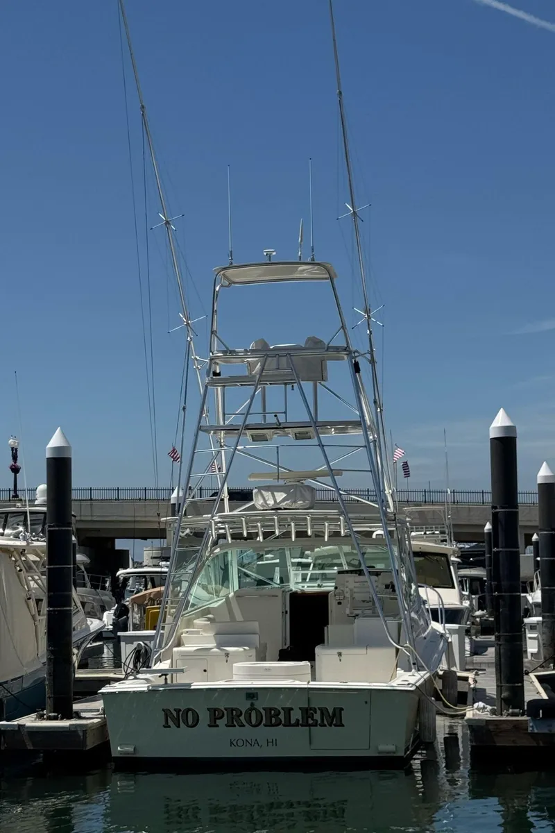 Slide: The Image of 1998 Cabo 35 Express boat docked at marina under clear blue sky. - 5