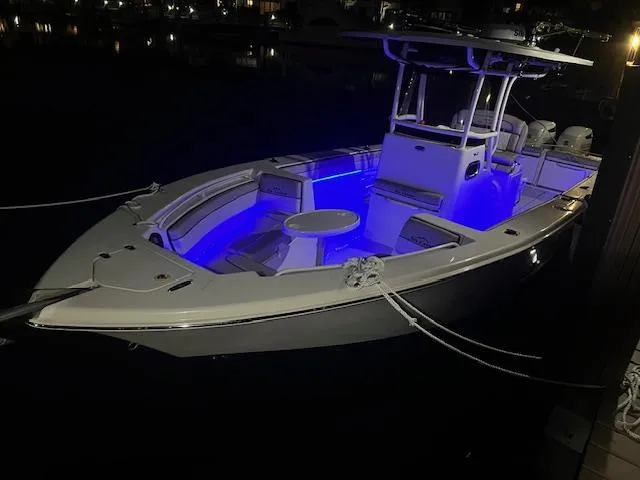 Slide: The Image of 2020 Sea Chaser 30 HFC CC boat with blue interior lights docked at night. - 26