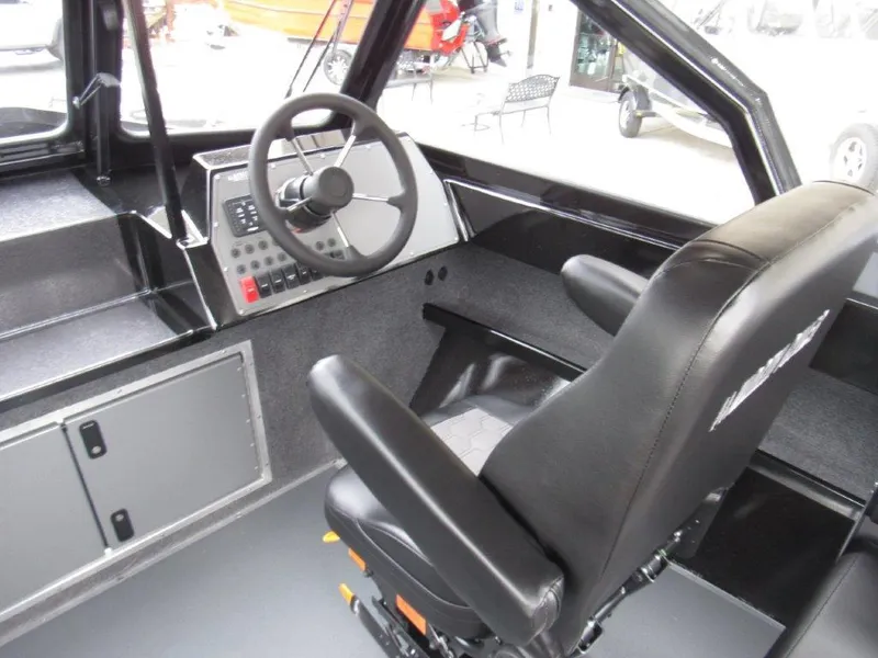 Slide: The Image of Interior of 2025 North River 23 SEAHAWK RTF boat, featuring steering wheel and control panel. - 12