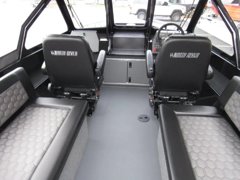 Slide: The Image of Interior of 2025 North River 23 SEAHAWK RTF boat, featuring seating and steering area. - 16