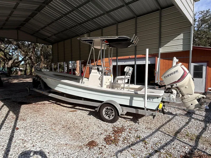 Slide: The Image of 2014 Andros Guide 20 boat with Evinrude motor, parked under a metal canopy. - 2