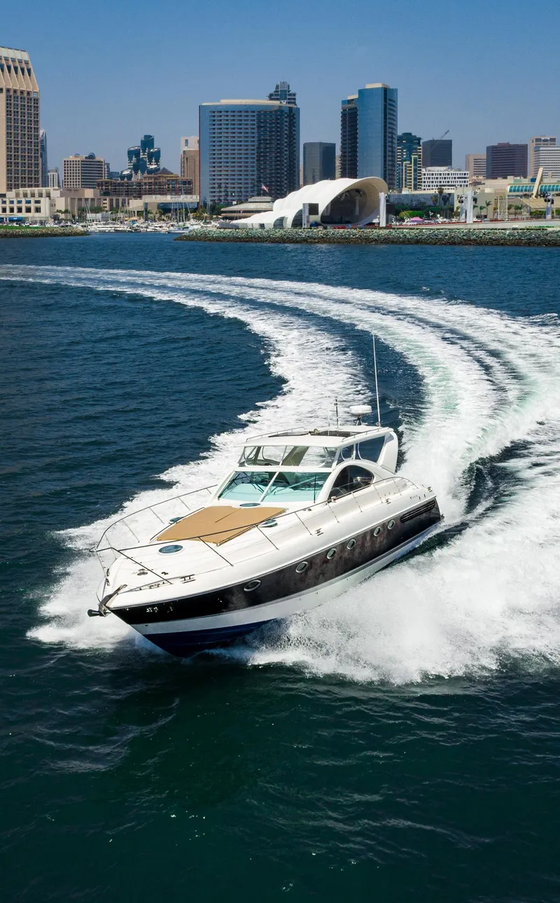 Slide: The Image of Fairline 48 Targa yacht cruising in city harbor, 2000 model, with skyline backdrop. - 11