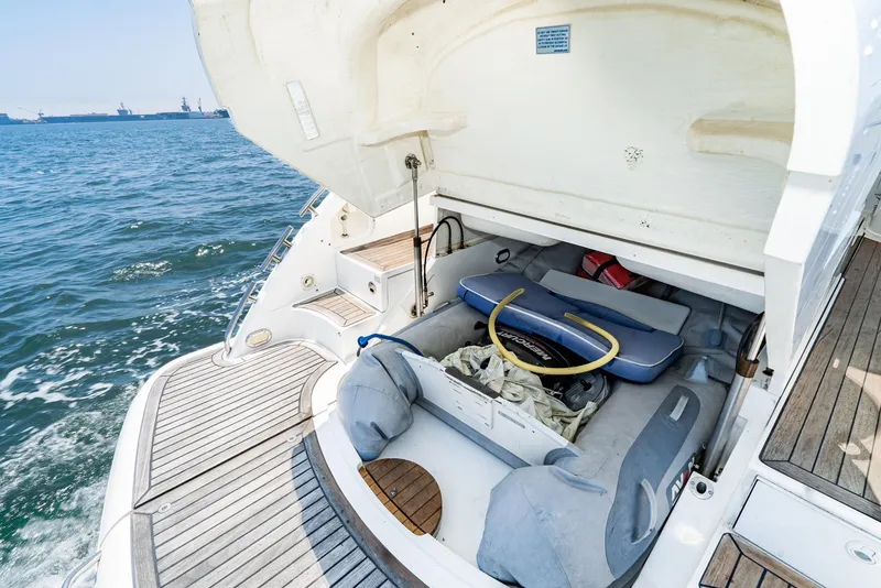 Slide: The Image of Fairline 48 Targa 2000 yacht with open storage compartment, docked on calm sea. - 16