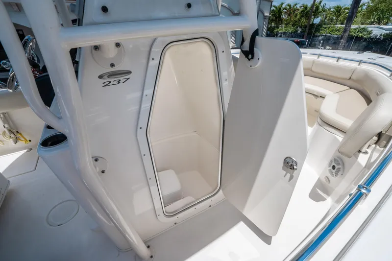 Slide: The Image of 2017 Cobia 237 CC boat interior with open storage compartment and seating area. - 25