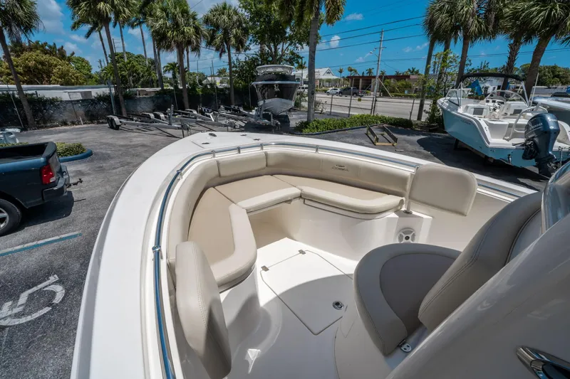 Slide: The Image of 2017 Cobia 237 CC boat with spacious seating, parked near palm trees. - 27