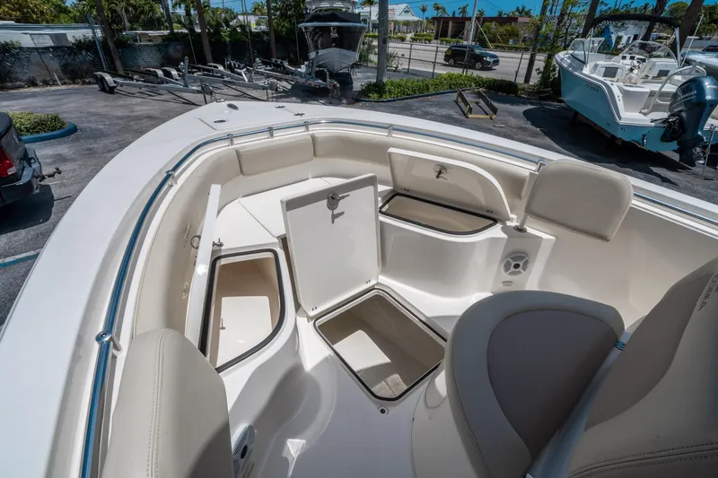 Slide: The Image of 2017 Cobia 237 CC boat interior with open storage compartments and seating. - 29