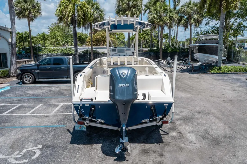 Slide: The Image of 2017 Cobia 237 CC boat with Yamaha 300 engine, parked outdoors under palm trees. - 3