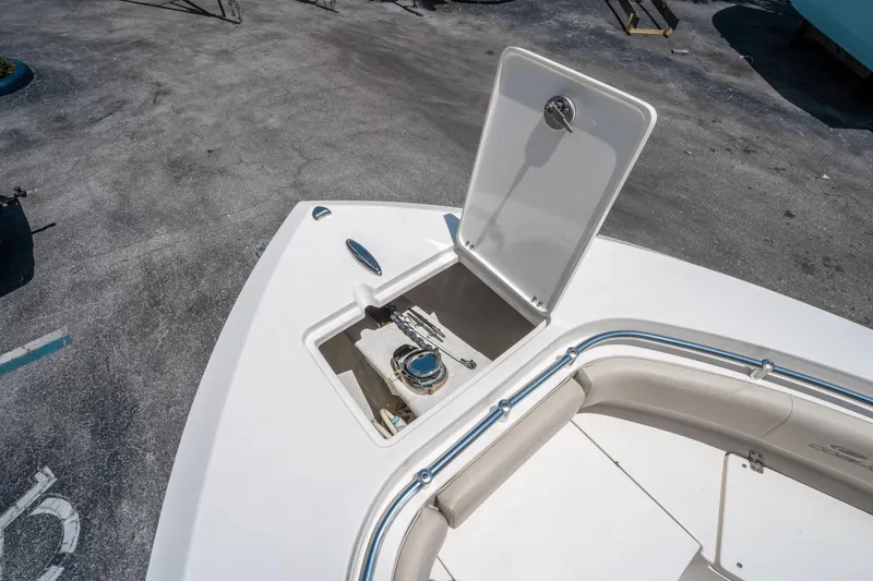 Slide: The Image of 2017 Cobia 237 CC boat anchor storage compartment with open hatch on deck. - 33