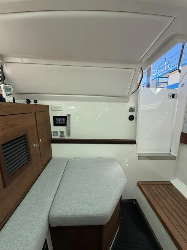 Slide: The Image of 2019 Axopar Brabus cabin interior with seating, wood accents, and control panel. - 10