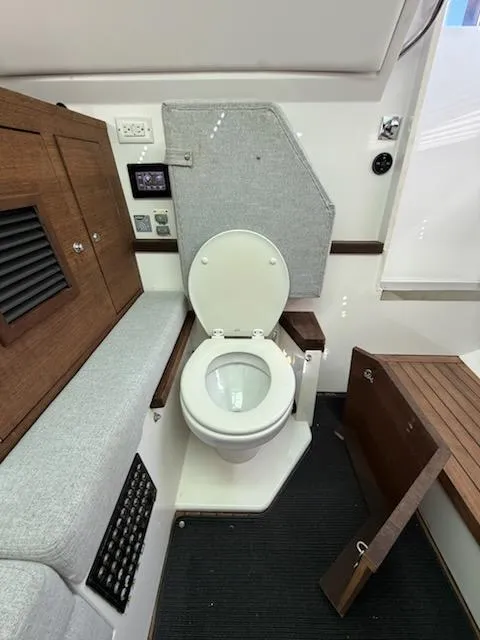 Slide: The Image of 2019 Axopar Brabus boat interior with modern toilet and wooden cabinetry. - 12